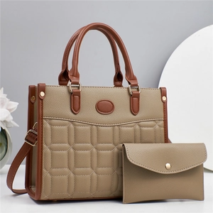 Detail of khaki pebbled leather tote bag set with square quilting and gold hardware