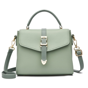 Sac à bandoulière vert motif litchi avec boucle dorée et sangle réglable sur fond blanc