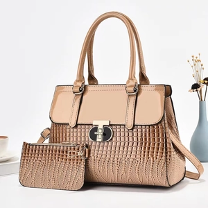 Detailed macro of lizard-patterned handbag with round metal buckle and mini pouch accessory