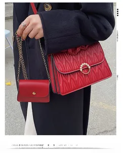 Détail d'un sac matelassé rouge avec boucle anneau perlé et échelle de mesure de taille
