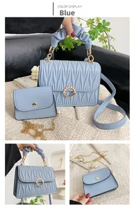 Détail d'un ensemble de sacs bleu clair avec boucle en perle et poignée nuage tressée