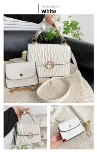 Détail du sac à main matelassé blanc avec boucle en perle et poignée plissée élégante