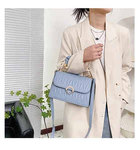 Détail du sac à main matelassé bleu clair avec boucle dorée ornée de perles élégantes