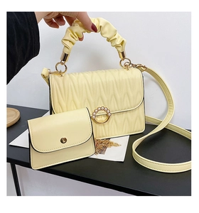 Détail du sac à main plissé jaune avec boucle en perles et petit porte-monnaie assorti