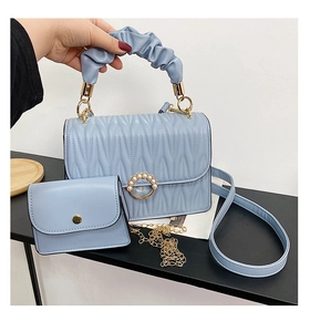 Détail du sac à main matelassé bleu clair avec boucle perle et poignée plissée