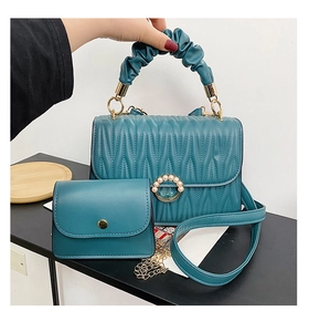 Détail du sac matelassé bleu sarcelle avec boucle perle et poignée en nuage