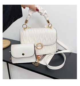 Détail de l'ensemble sac en cuir blanc matelassé avec boucle en perles et poignée souple