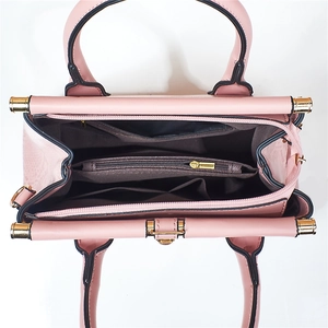 Vue intérieure d'un sac à main rose avec compartiments et fermetures éclair dorées