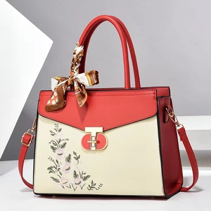 Red and beige contrast leather handbag with floral embroidery and decorative silk scarf