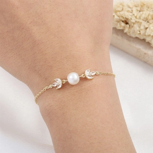 Elegant gold pearl bracelet with leaf-shaped marquise zircons on a model's wrist