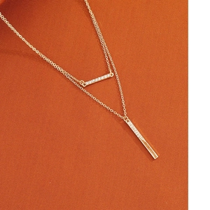 Élégant collier double couche doré avec pendentifs barres géométriques et zircons blancs fins