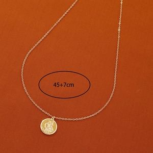 Détail du pendentif pièce d'or avec relief religieux et échelle de longueur de 45+7cm