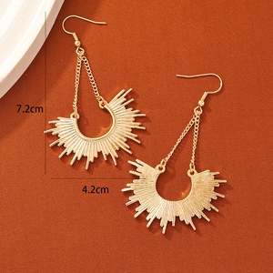 Golden bohemian tassel earrings in a radial sunburst design with hook fastener