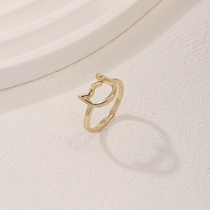 Minimalist golden hollow cat ear ring displayed on a modern textured platform