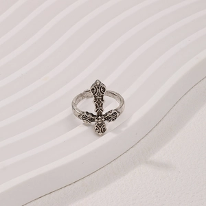 Vintage silver textured cross ring with gothic scroll engravings on a white background