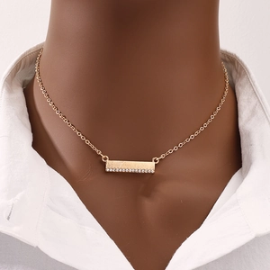 Minimalist gold bar necklace with zircon pavé pendant worn on an elegant female neck