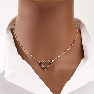 Golden necklace with pixelated hollow heart pendant on a minimalist cross chain