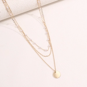 Collier multi-rangs doré élégant avec perles blanches et pendentif rond sur pierre