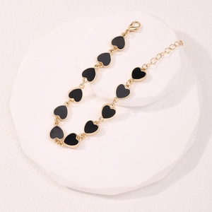 Elegante bracciale a cuore placcato oro con ciondoli in smalto nero e chiusura a moschettone