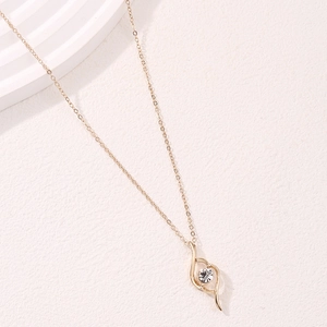Elegant gold necklace with a fluid teardrop pendant and sparkling white gemstone