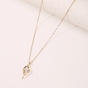 Elegant gold necklace with curved pendant and sparkling round zircon on textured background