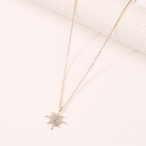 Elegante collana dorata con ciondolo a stella a otto punte e zirconi su pietra