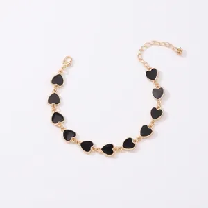 Bracciale a catena dorata minimalista con dieci ciondoli a cuore in smalto nero