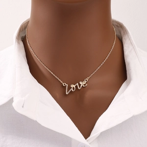 Collier doré avec pendentif Love manuscrit sur chaîne fine porté par un mannequin