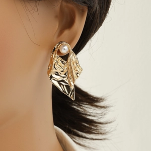 Golden irregular alloy stud earrings with white pearl accent on model for stylish look