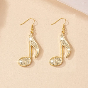 Detailed macro view of gold-tone music note earrings with sparkling pave-set zircons