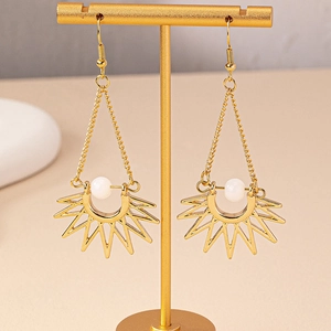 Bohemian gold sunburst drop earrings with opal beads on a stylish display stand