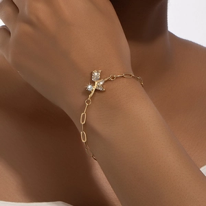 Elegant gold rose bracelet with inlaid rhinestones shown on a model's wrist