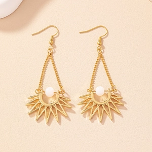 Detail of bohemian sunburst drop earrings with gold finish and white bead inlay