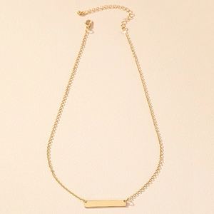 Détail d'un collier doré avec pendentif rectangulaire minimaliste et fermoir mousqueton