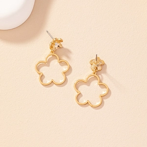 Macro detail of gold-tone hollow floral earrings with sparkling cubic zirconia inlay