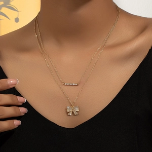 Double-layered gold bow necklace featuring zircon micro-pave pendants and delicate chain