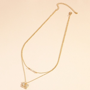 Elegant gold-tone double-layer necklace with a sparkling rhinestone bow pendant