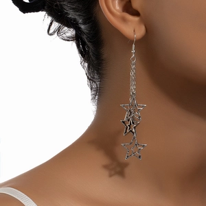 Vintage silver tassel earrings with cascading hollow pentagram stars on model's ear