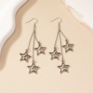 French vintage silver tassel star earrings with three hanging chains on textured stone base