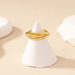 Minimalist golden multilayer trinity ring interlaced on white conical jewelry display