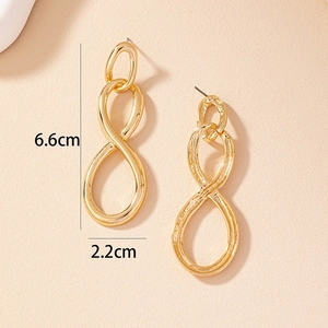 Detailed view of gold geometric figure 8 drop earrings measuring 6.6cm by 2.2cm