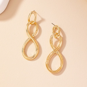 Detailed macro view of golden figure eight earrings with smooth polished finish