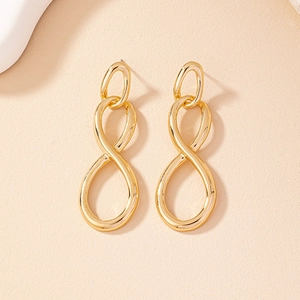 Elegant gold figure-eight drop earrings with a polished finish on a warm beige background
