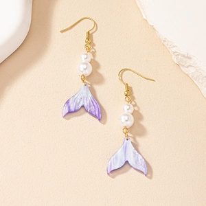 Détail des boucles d'oreilles queue de sirène dorées avec perles et dégradé violet
