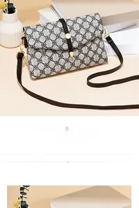 Détail du motif trèfle sur un sac bandoulière minimaliste avec boucle dorée élégante