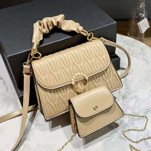 Beige quilted handbag set with braided handle, pearl clasp and mini chain bag accessory