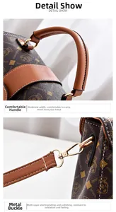 Detail view of the brown monogram leather handle and polished golden metal hardware