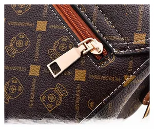Detail view of premium leather texture with brand lettering and golden zipper puller