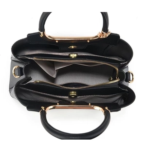Top view of black tote bag interior with multiple compartments and gold hardware