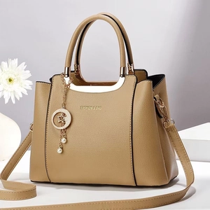 Detail of lychee pattern leather tote with gold metal handle and star pearl charm